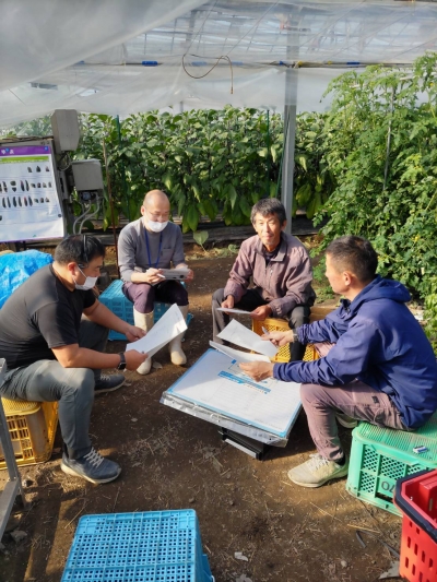 資料の説明を行う普及指導員（左から２人目）と資料の内容を検討する農家