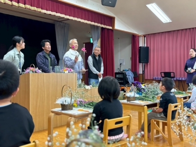 アレンジメント教室において、生産者が園児の前で花を持って説明している様子
