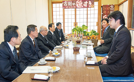 中村隆象（なかむら りゅうぞう）市長と「鶏すき」を味わい、市の概要について説明を受ける様子