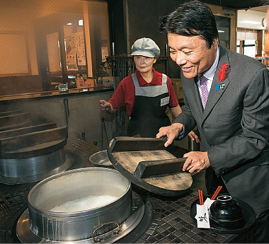 かまど炊きご飯をのぞき込む知事