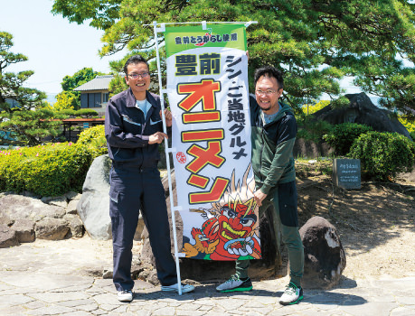 「豊前ご当地グルメ推進委員会」委員長の大森和教（（おおもり かずのり））さん（右）と朝倉亮（あさくら まこと）さん（左）