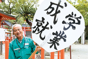 大うちわを持つ振興会会長の山口千里さんの写真