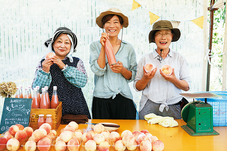 桃やもものジュースを持って微笑む3人の女性の写真