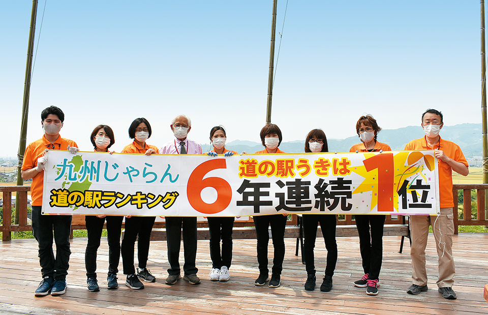 9人で「九州じゃらん道の駅ランキング“道の駅うきは” 6年連続1位」の横断幕を持つ写真