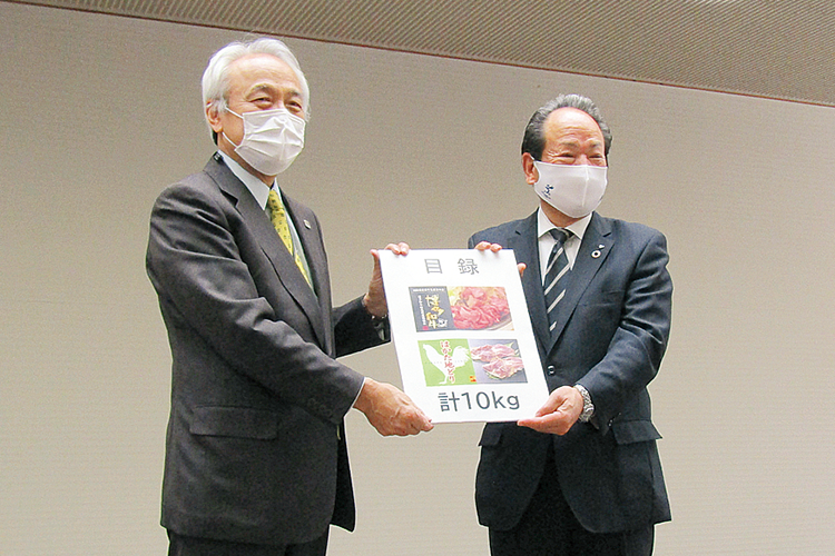 激励を込めた県産の畜産物を贈呈している写真