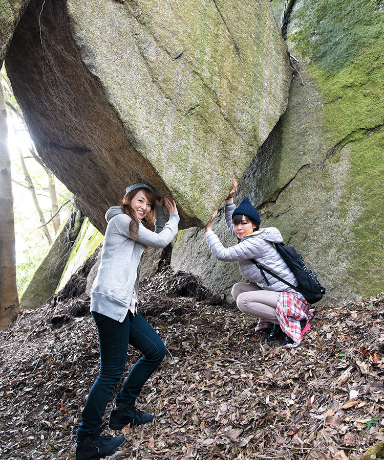 落ちない岩に手を添える女性2人の写真