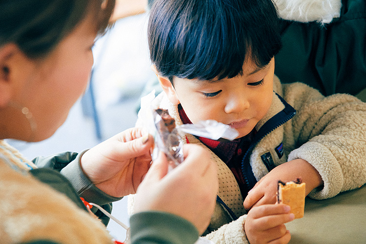 あんとナッツクッキーのサンドを食べている子供たちの写真