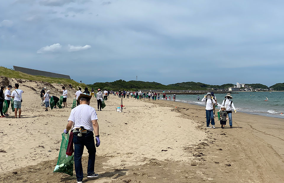 地域の人々が砂浜を清掃している写真 地域の人々が砂浜を清掃している写真
