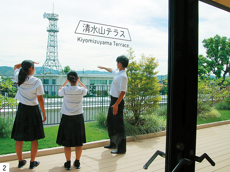 テラスから清水山を眺める3人の生徒の写真