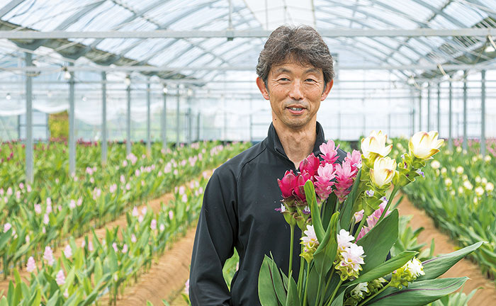 クルクマを持ち笑顔の一ノ宮浩さんの写真