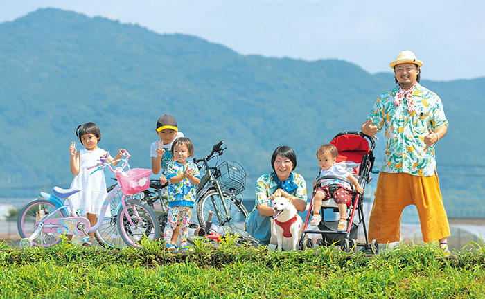 田んぼの中で海老澤さん家族が横一列に並んでいる写真