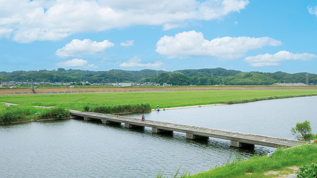 彦山川にかかる橋を自転車で渡っている写真
