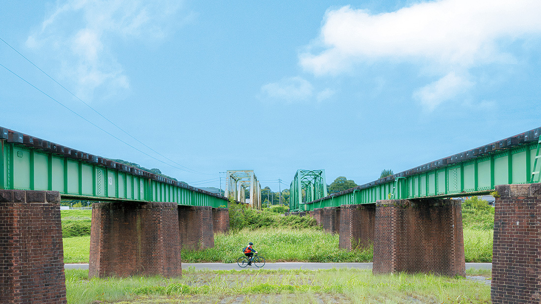 平成筑豊鉄道の鉄橋沿いをサイクリングしている写真