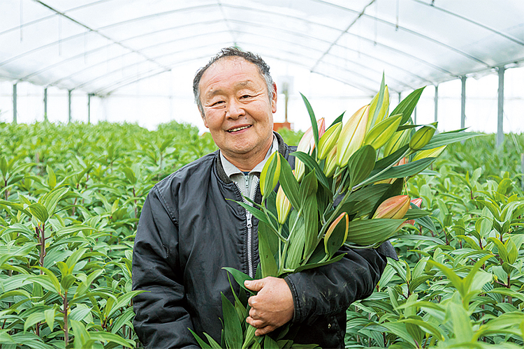 オリエンタルユリを持つ石井秀樹さん