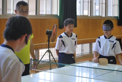 小学生がアイマスクをしてサウンドテーブルテニスを体験している写真です。