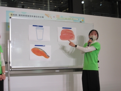 福岡県栄養士会によるミニセミナーの様子です。ホワイトボードを指差して説明しています。