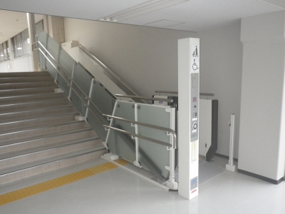 階段の右側に車いす用斜行型昇降機が設置されている写真です。