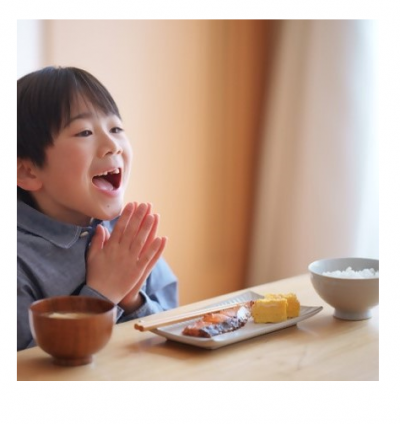 ごはん・みそ汁・焼き魚・卵焼きの朝食を前にして、子どもは笑顔で「いただきます。」の挨拶をしている。