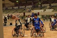 体育館内で車いすに乗りながらボールを争奪する選手の画像