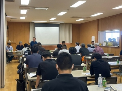 室内での講演のようす。一般社団法人伊方営農組合の仲村代表理事が話しているのを参加者が座って聞いている。