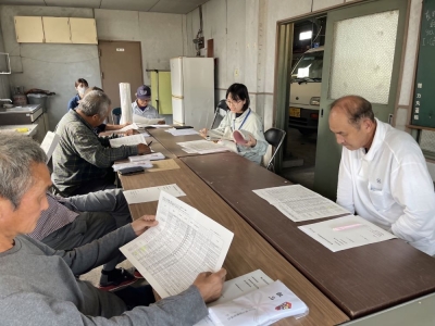 検討会で配布資料の説明を行っている様子