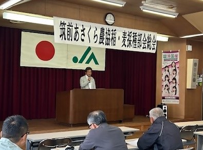 演台に立ち挨拶をする部会長の様子
