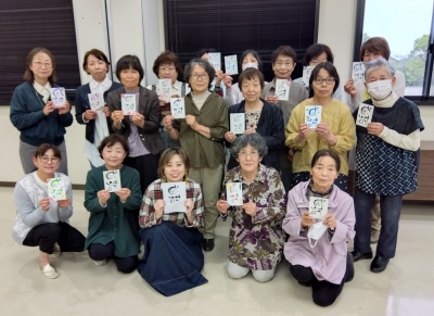 力作を手に集合写真