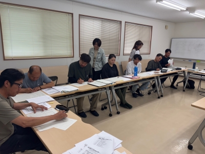 簿記の演習に取り組む研修生と助言する普及員