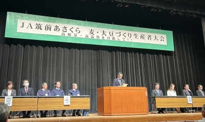 ステージ中央で昨年産麦大豆の概況を説明する様子